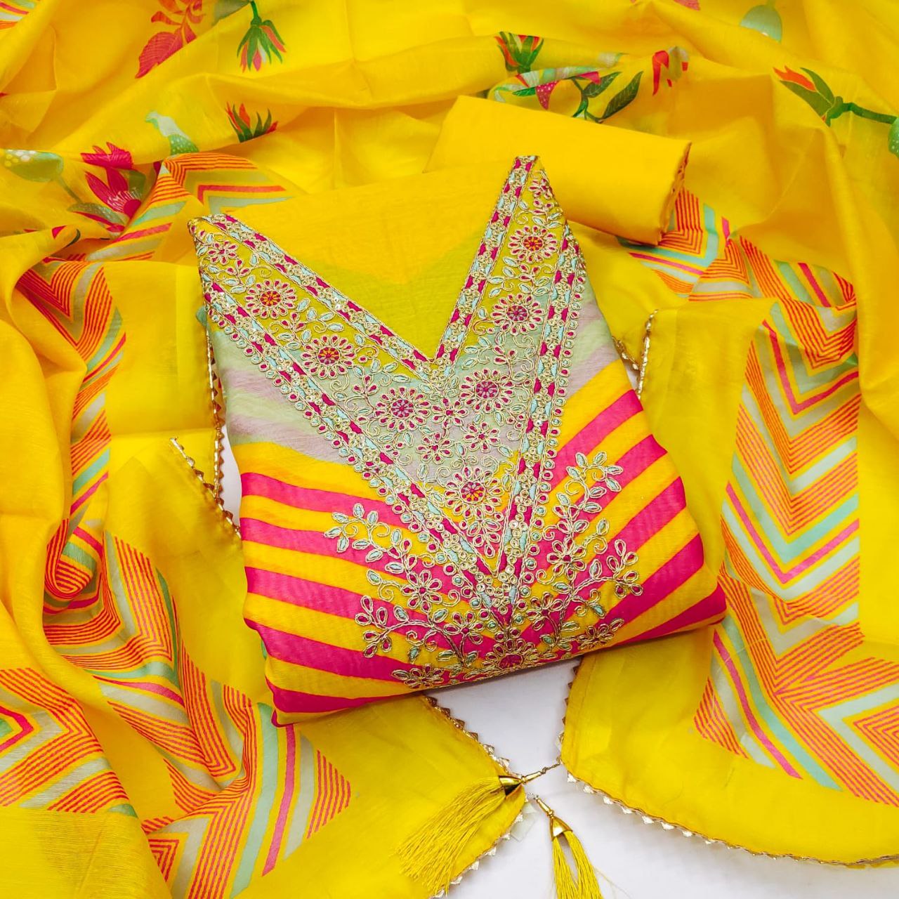 Colorful embroidered blouse with yellow fabric and patterns on a white background